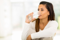 beautiful young woman drinking water in the morning